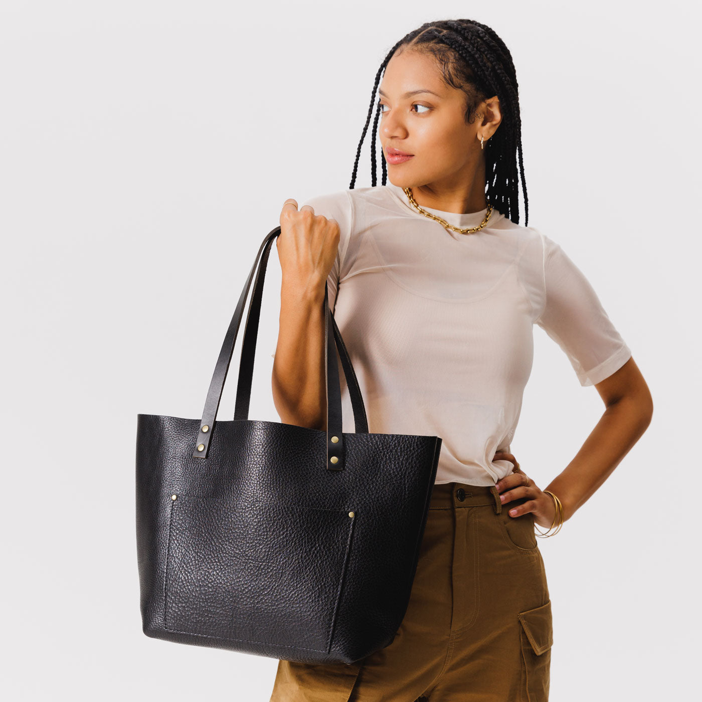 Pebbled--black Classic | Model holding large leather tote bag with sturdy bridle handles and front pocket