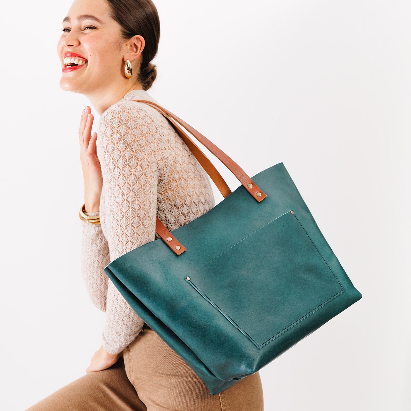 Caribbean*Classic | Model holding large leather tote bag with sturdy bridle handles and front pocket