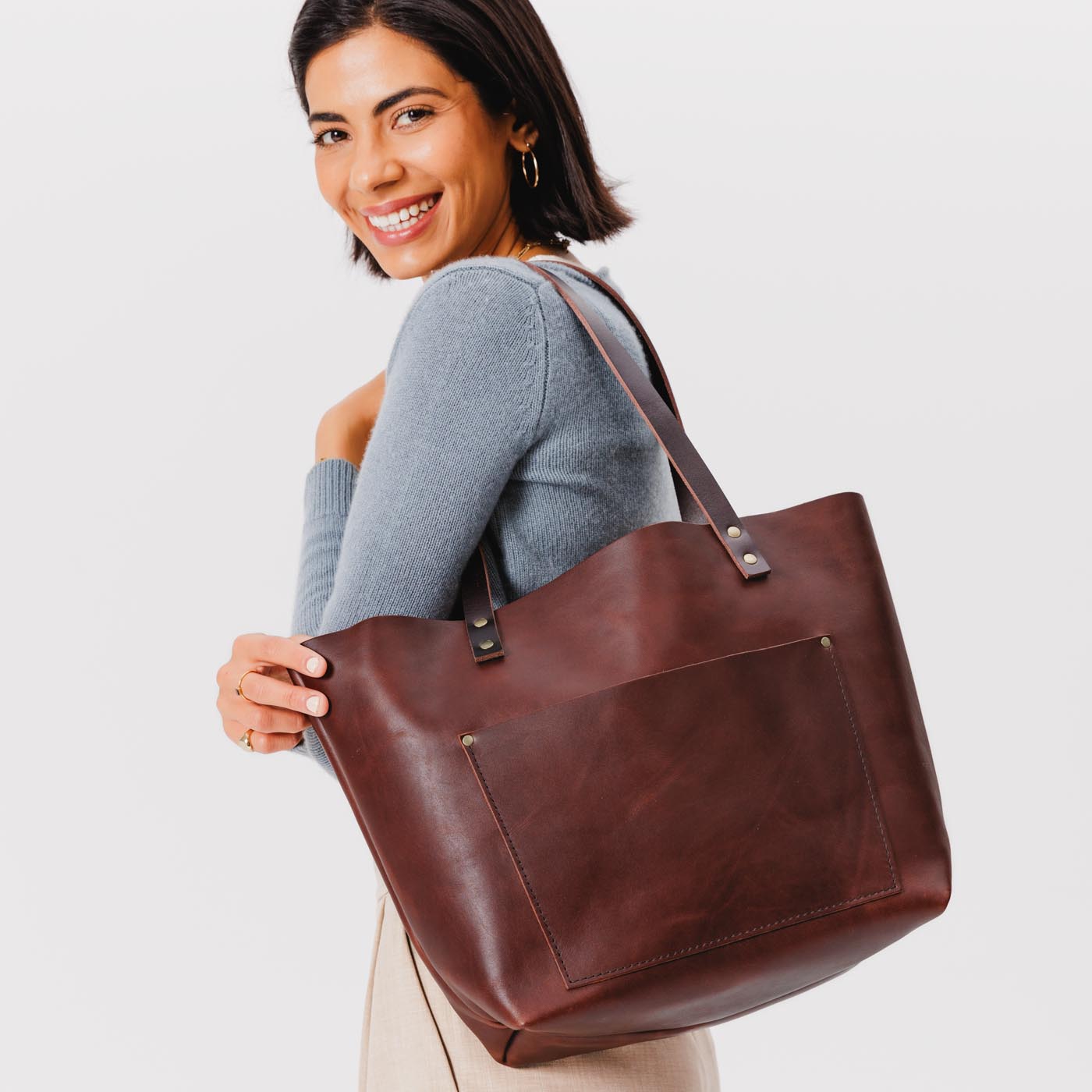 Cognac Classic  | Model holding large leather tote bag with sturdy bridle handles and front pocket