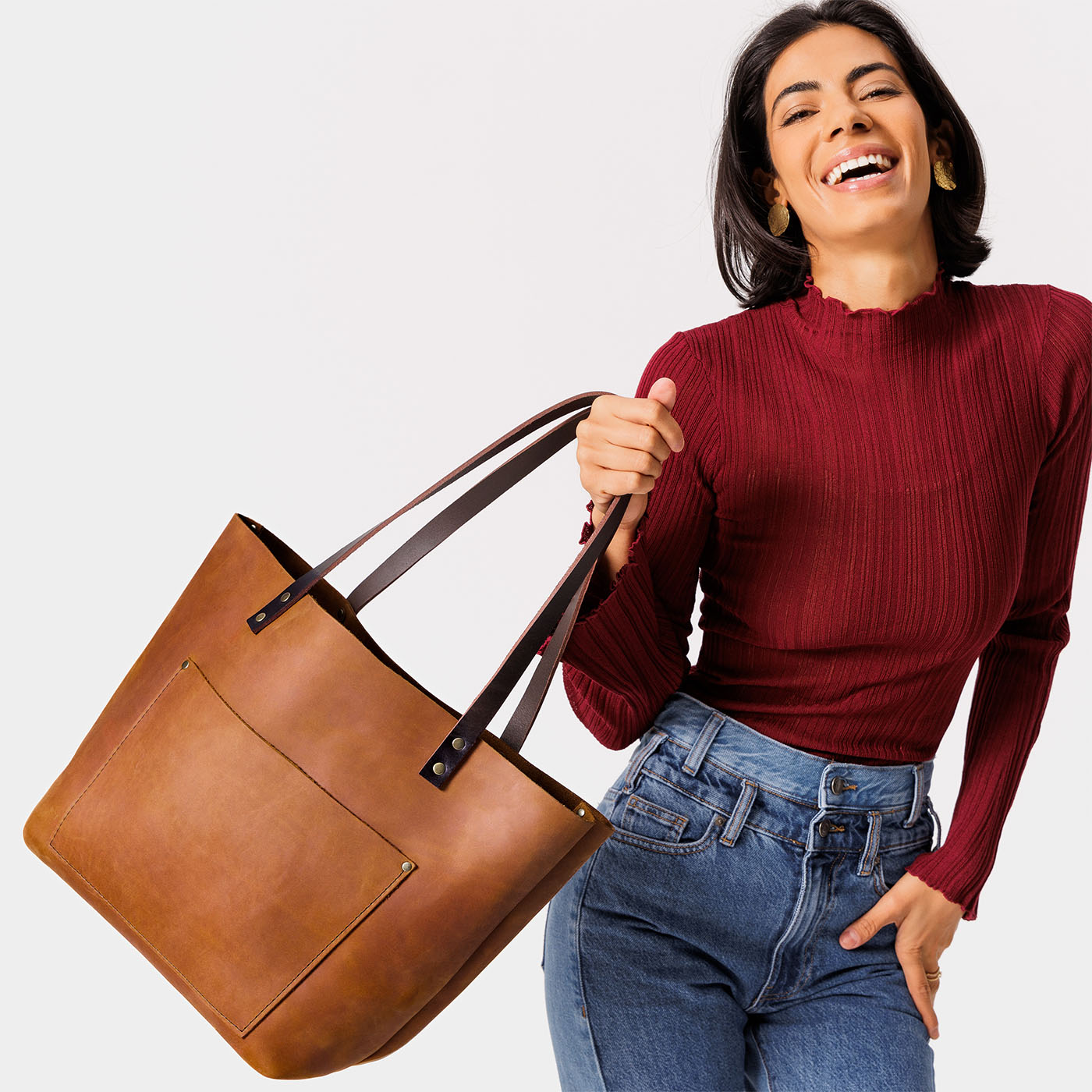 Dakota Classic | Model holding large leather tote bag with sturdy bridle handles and front pocket