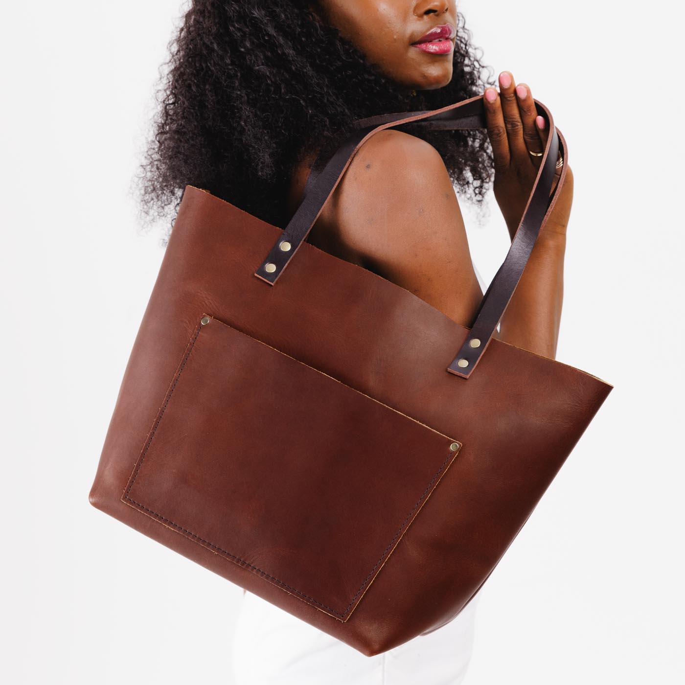 Durango Classic | Model holding large leather tote bag with sturdy bridle handles and front pocket