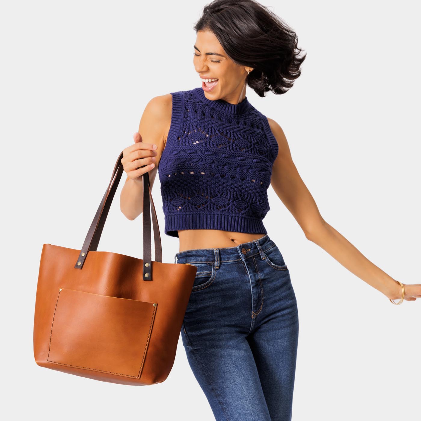 Honey*Classic | Model holding large leather tote bag with sturdy bridle handles and front pocket