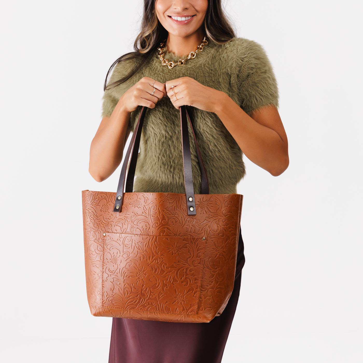 Meadow Classic | Model holding large zipper leather tote bag with sturdy bridle handles and front pocket