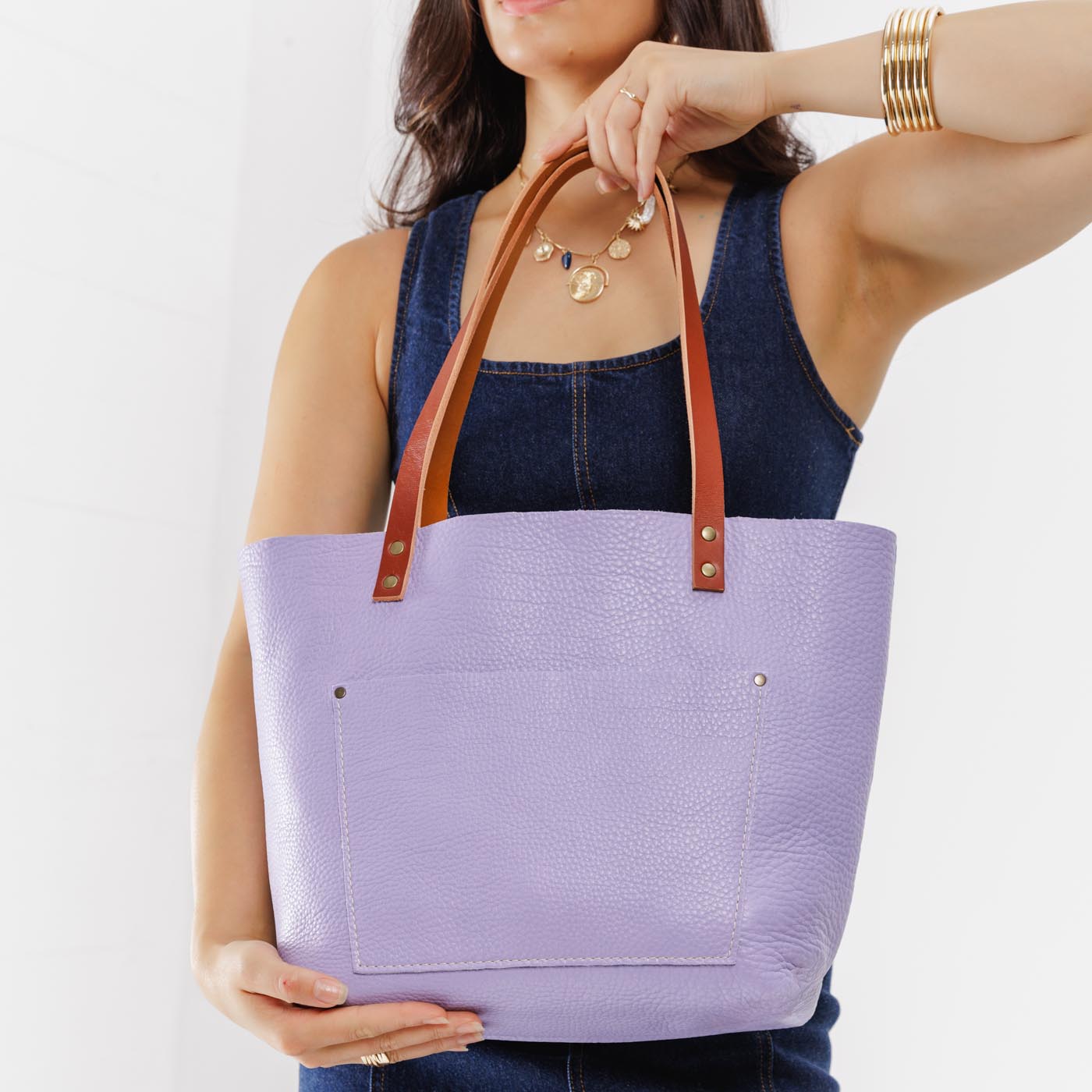 Wisteria Classic | Model holding large leather tote bag with sturdy bridle handles and front pocket