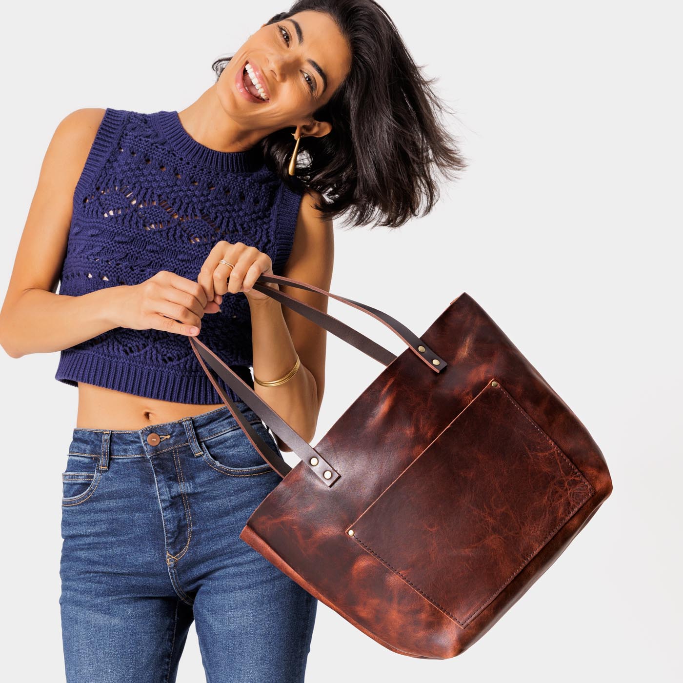 Lava Classic | Model holding large leather tote bag with sturdy bridle handles and front pocket