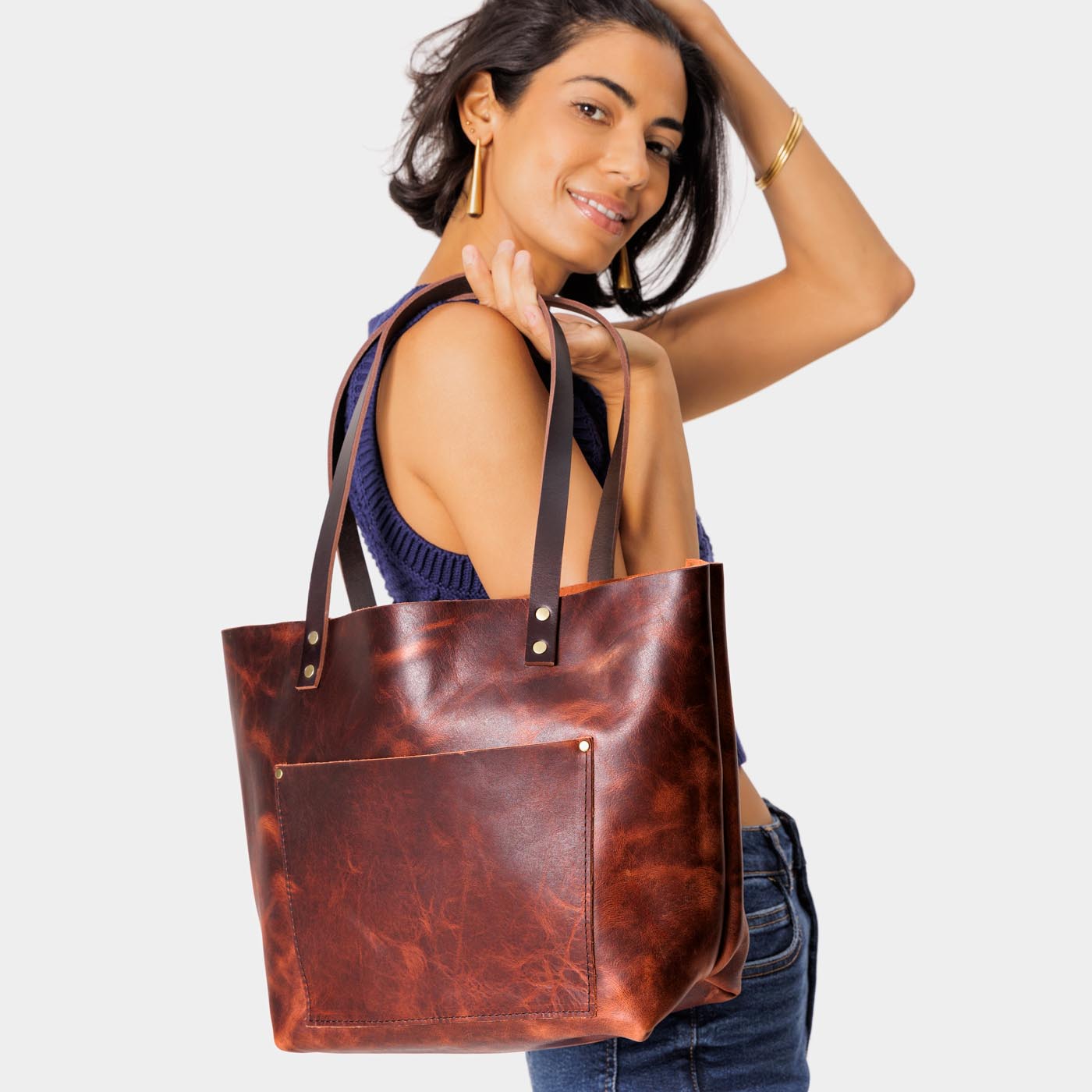 Lava*Classic | Model holding large leather tote bag with sturdy bridle handles and front pocket