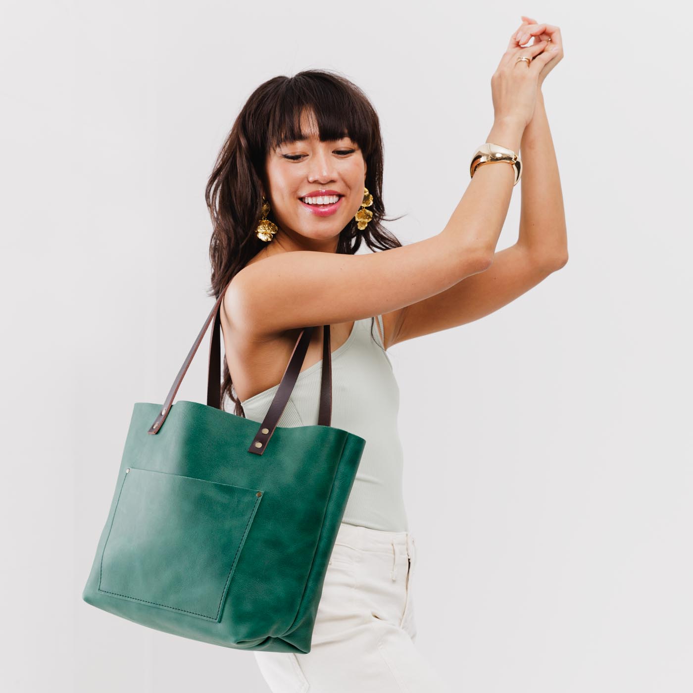 Surf*Classic | Model holding large leather tote bag with sturdy bridle handles and front pocket