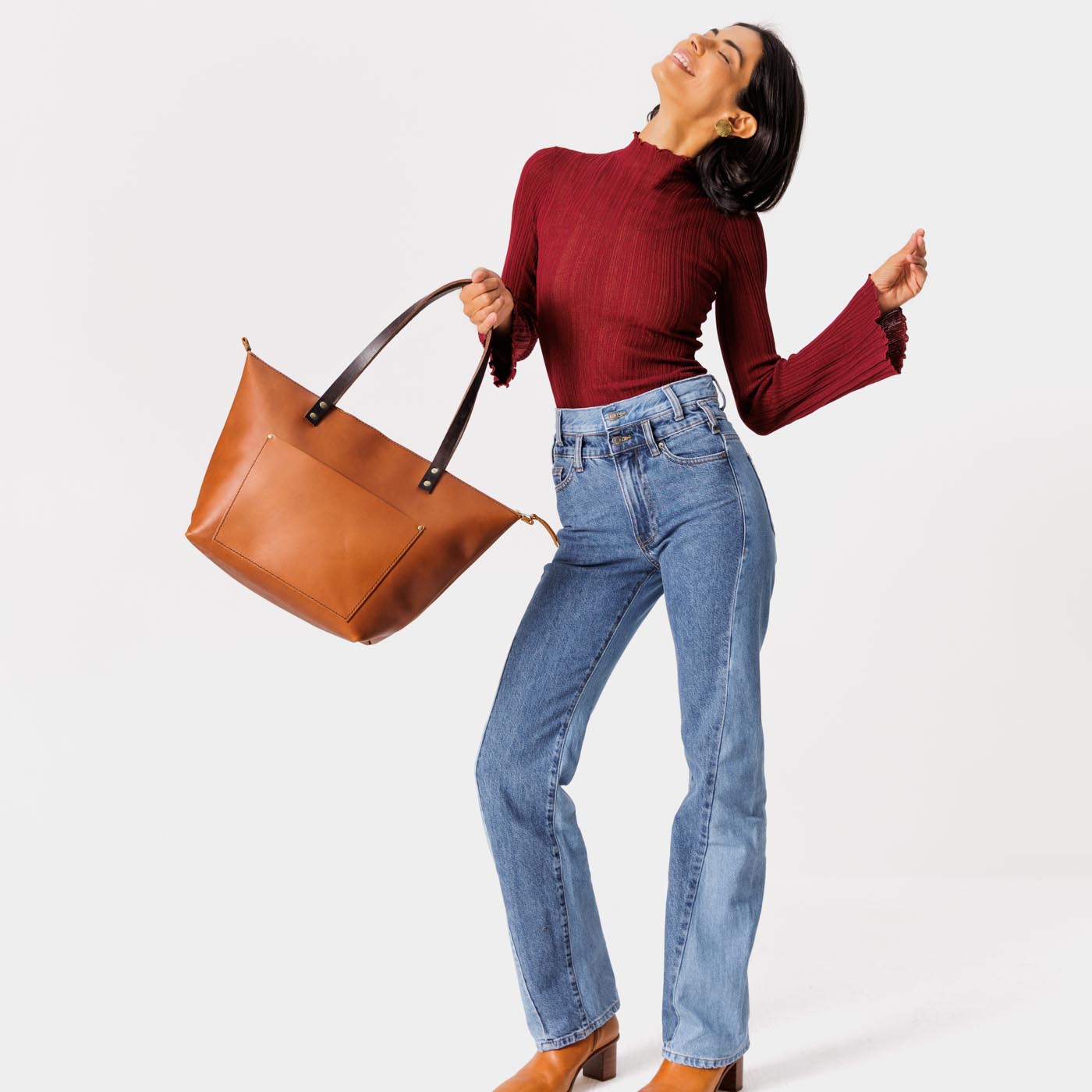 Honey*Zipper | Model holding large zipper leather tote bag with sturdy bridle handles and front pocket