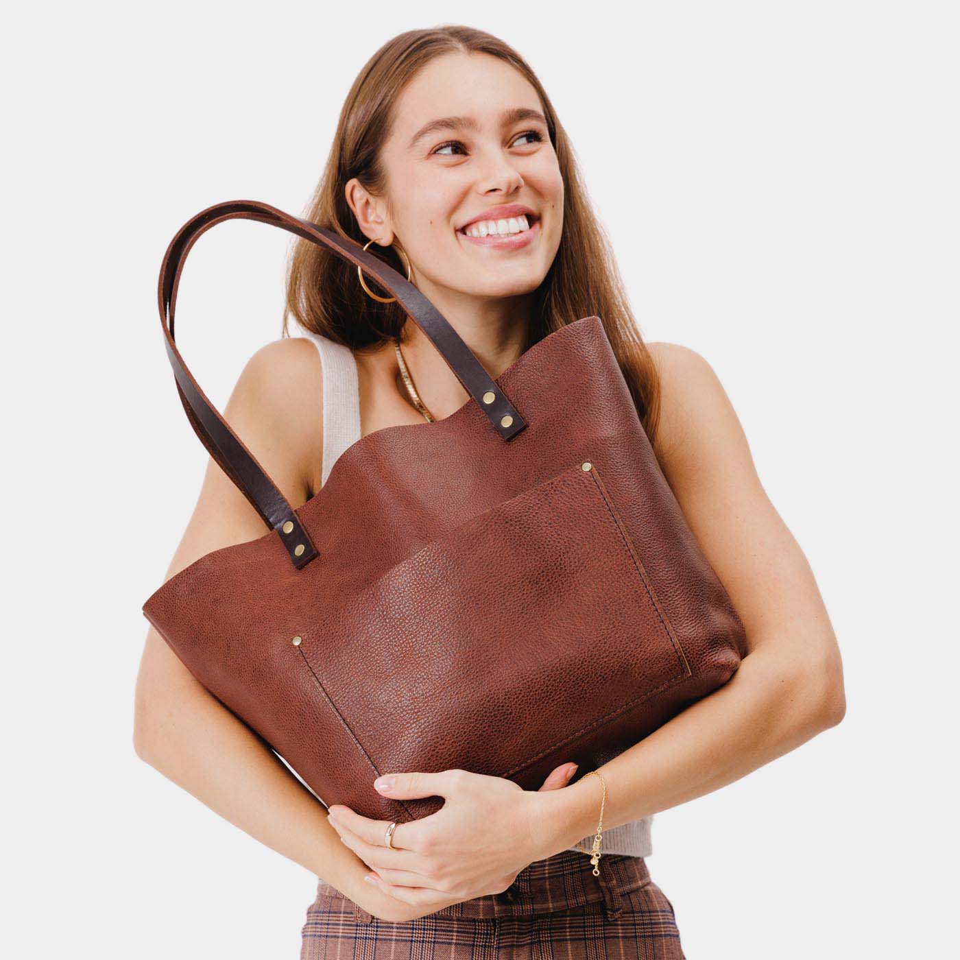 Nutmeg*Classic | Model holding large leather tote bag with sturdy bridle handles and front pocket