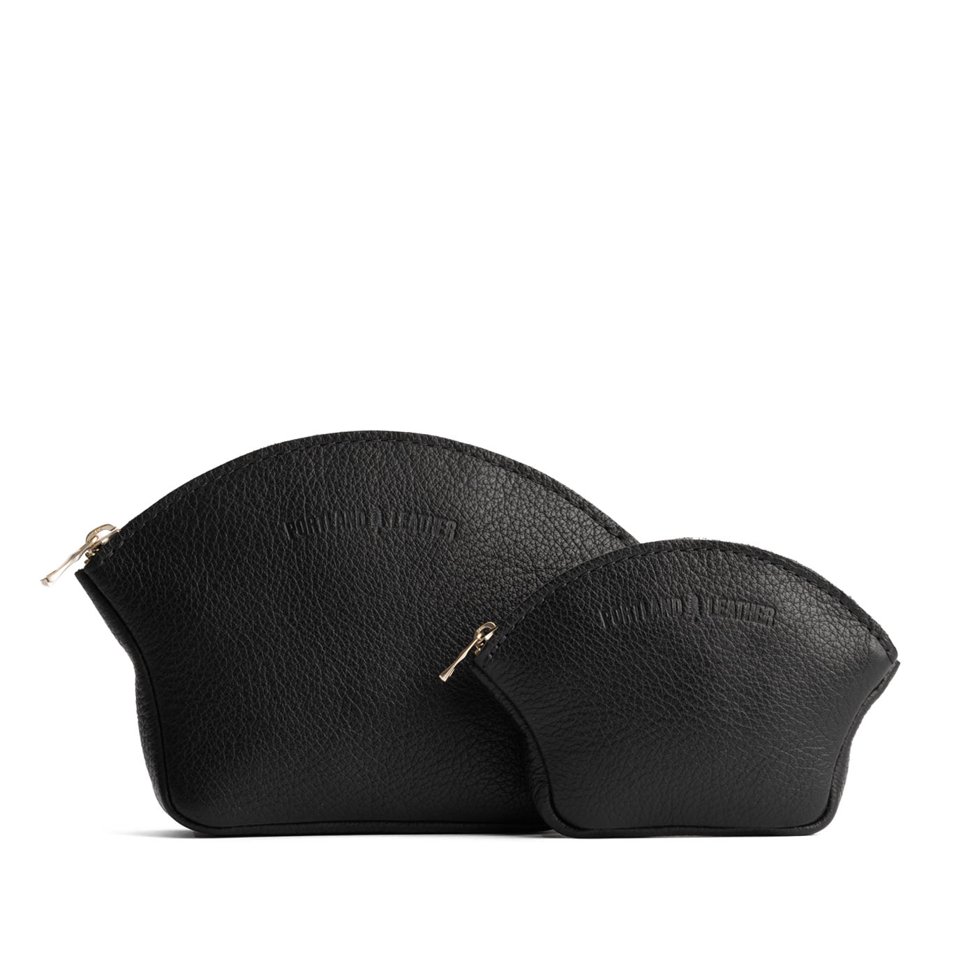 Pebbled--black | Comparison shot of small and large seashell shaped leather makeup bags with curved top zipper and flat bottom