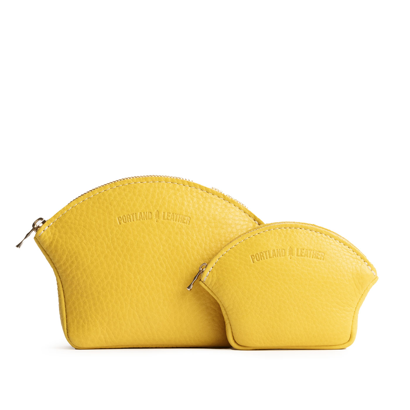 Naples | Comparison shot of small and large seashell shaped leather makeup bags with curved top zipper and flat bottom