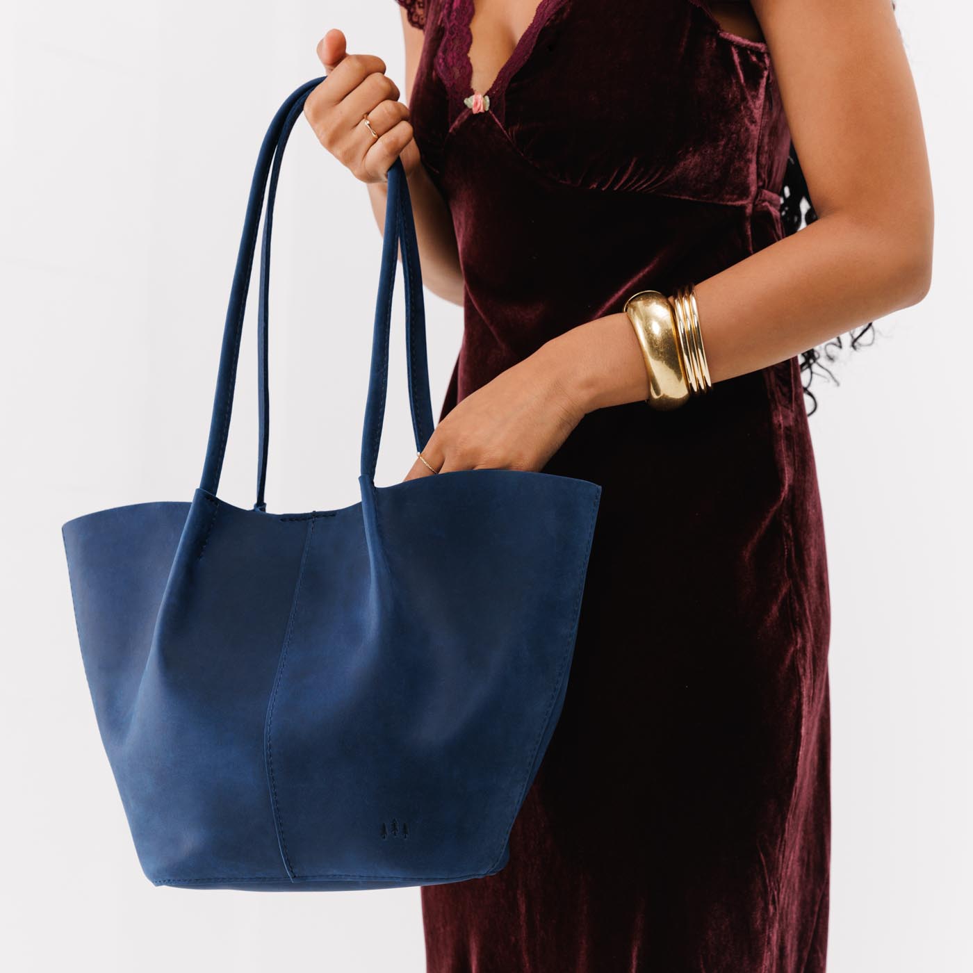 Deep Water Large | Model holding wide bucket shaped tote bag with matching leather handles