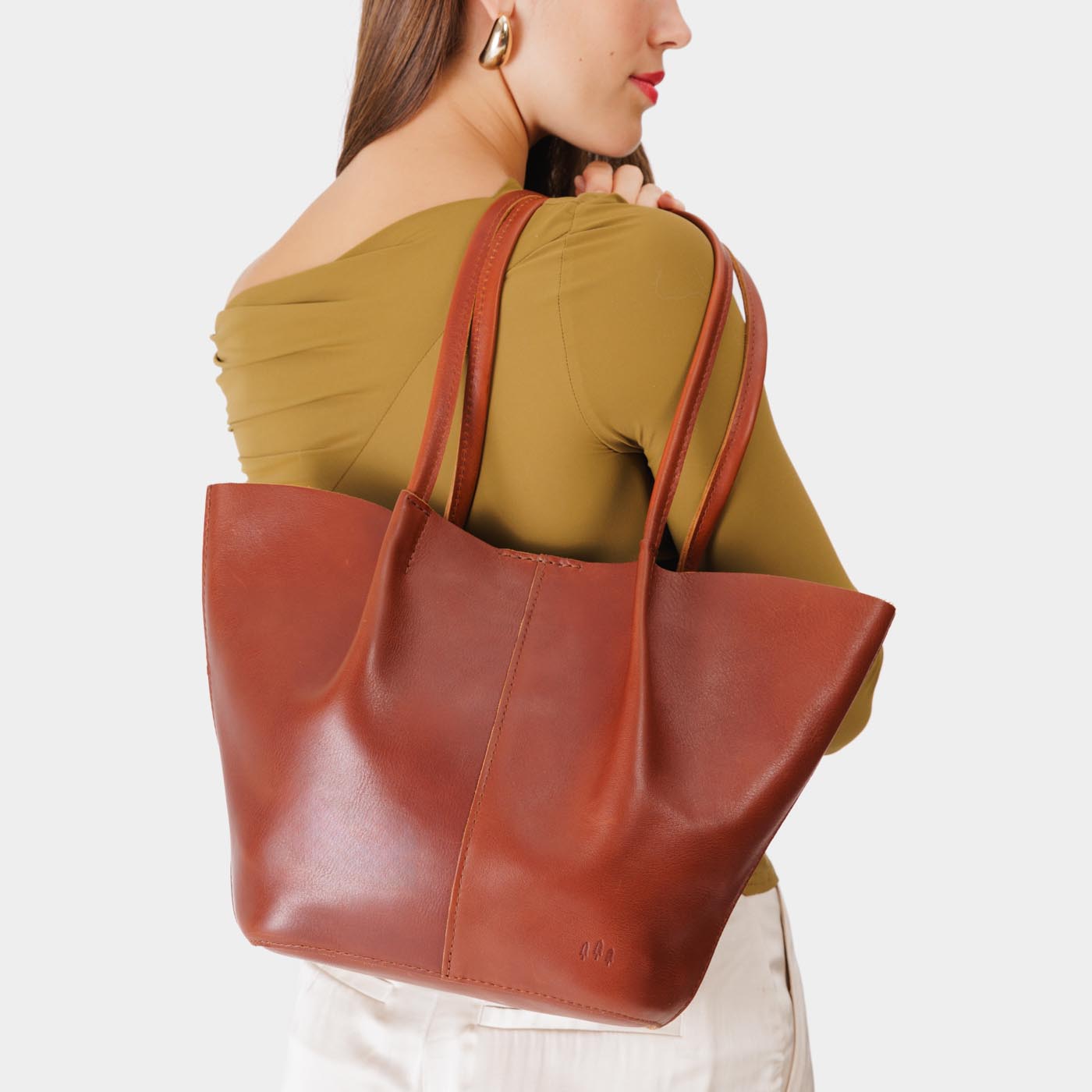 Chestnut*Large | Model holding wide bucket shaped tote bag with matching leather handles