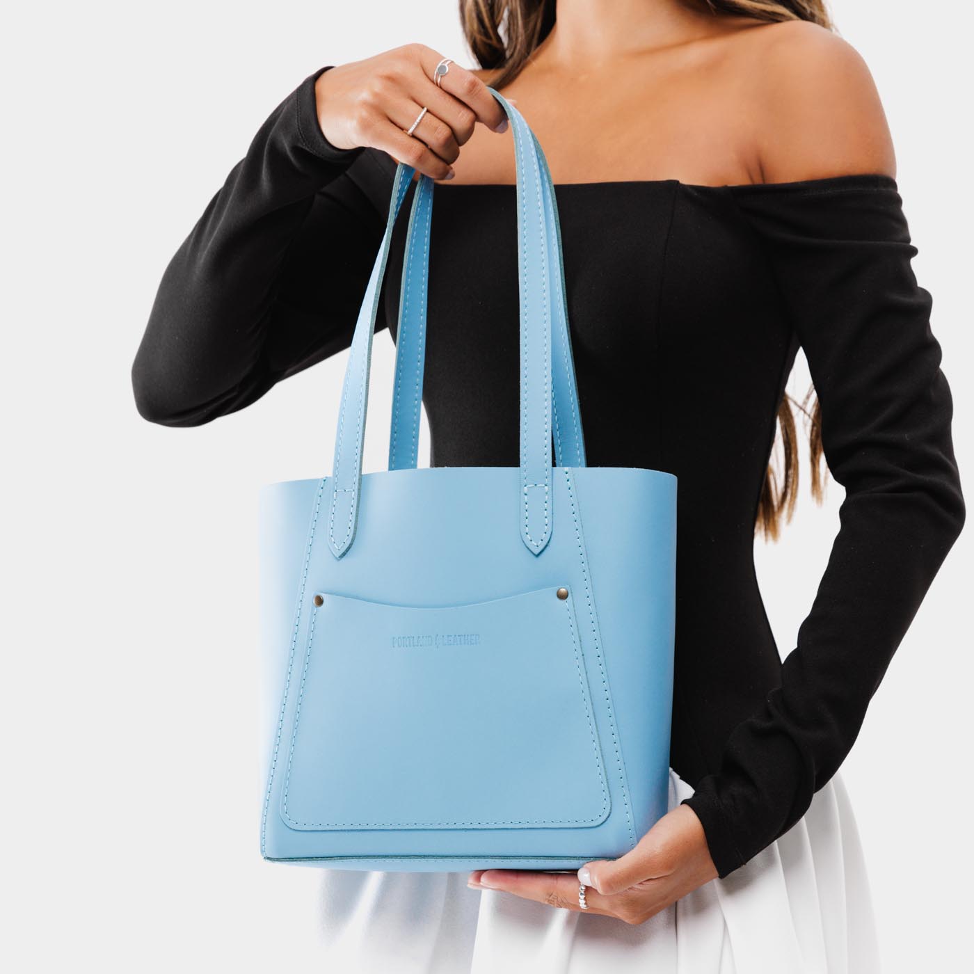 Glacial Blue*Small | Model holding dual shoulder strap tote bag with an exterior pocket