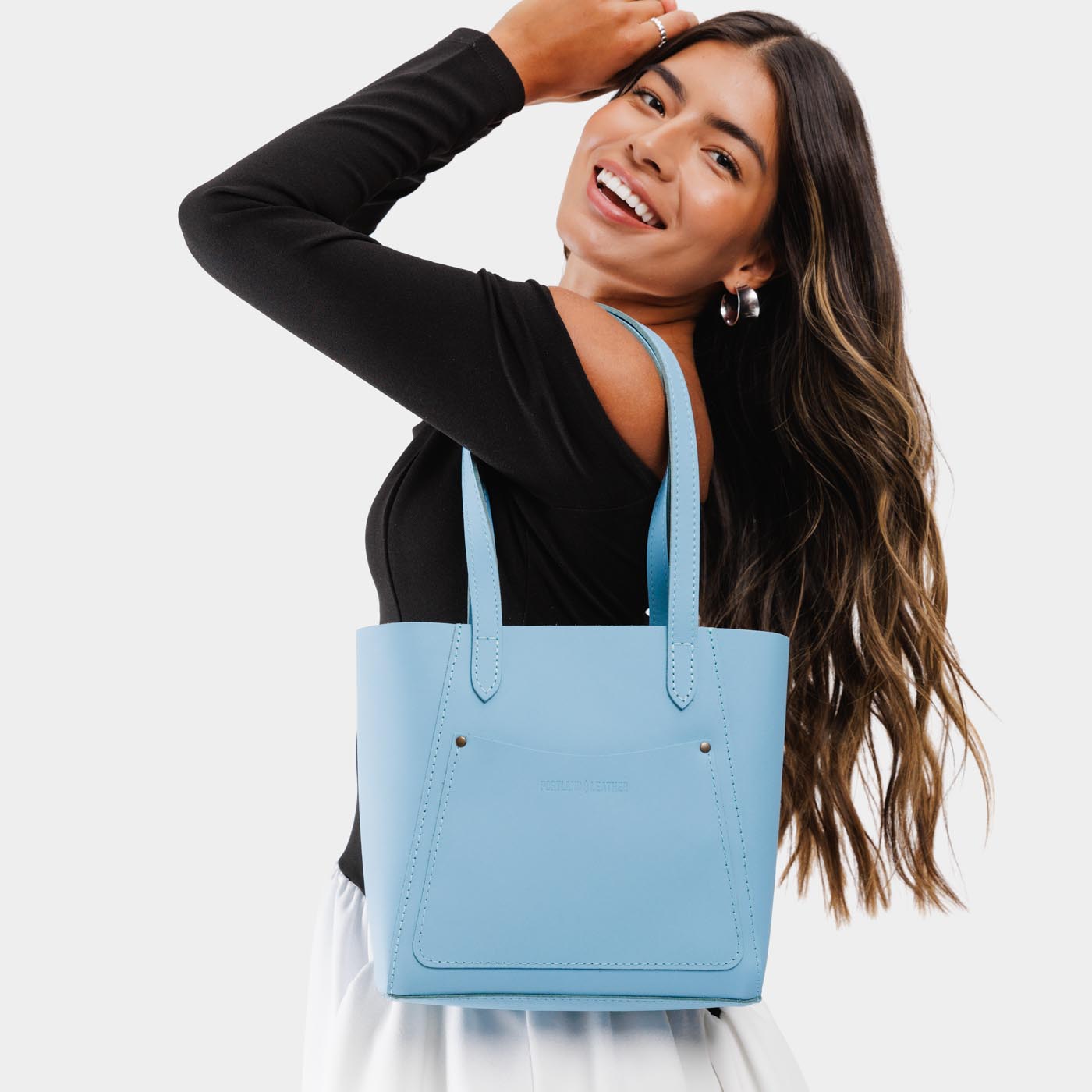 Glacial Blue Small | Model holding dual shoulder strap tote bag with an exterior pocket