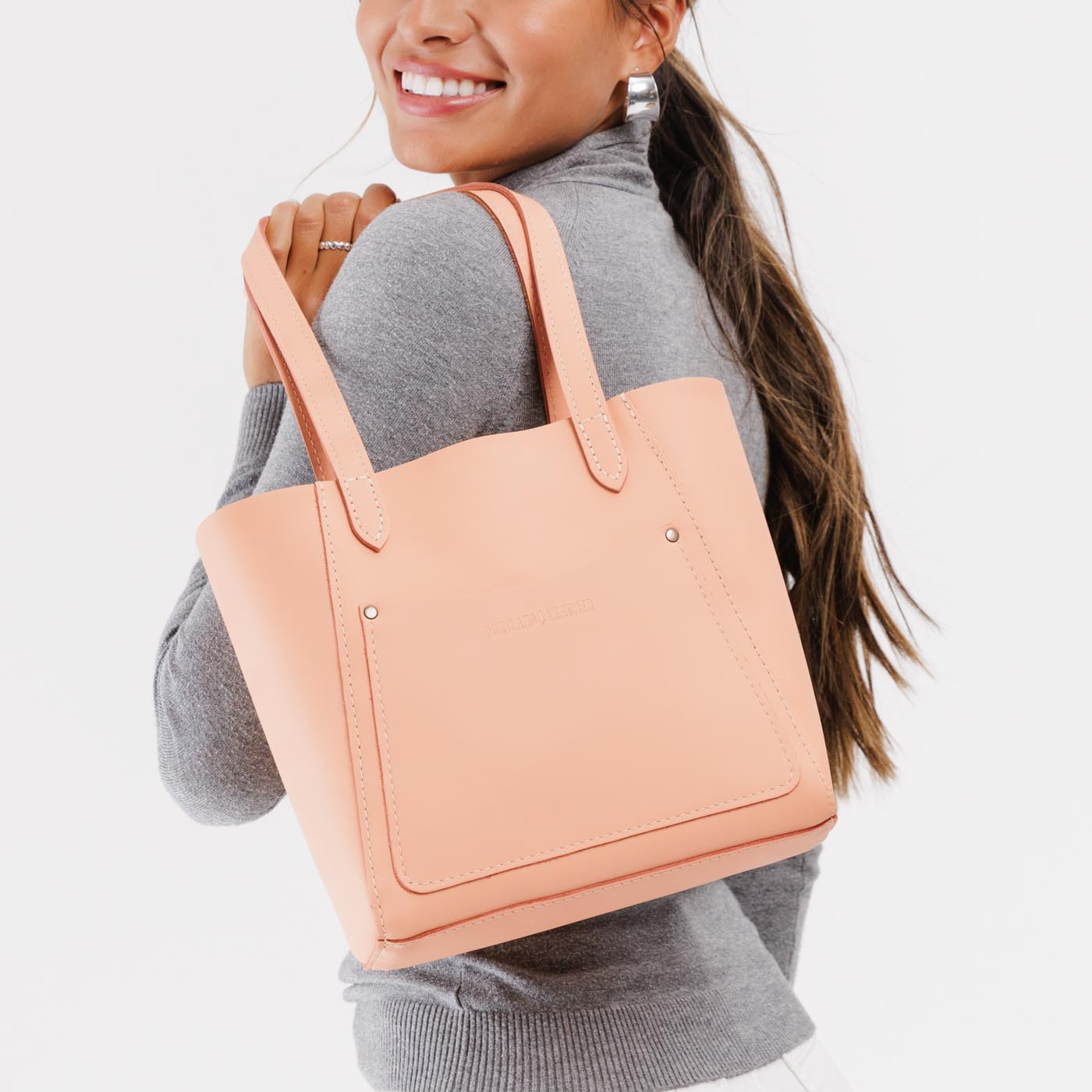 Mamey*Small | Model holding dual shoulder strap tote bag with an exterior pocket