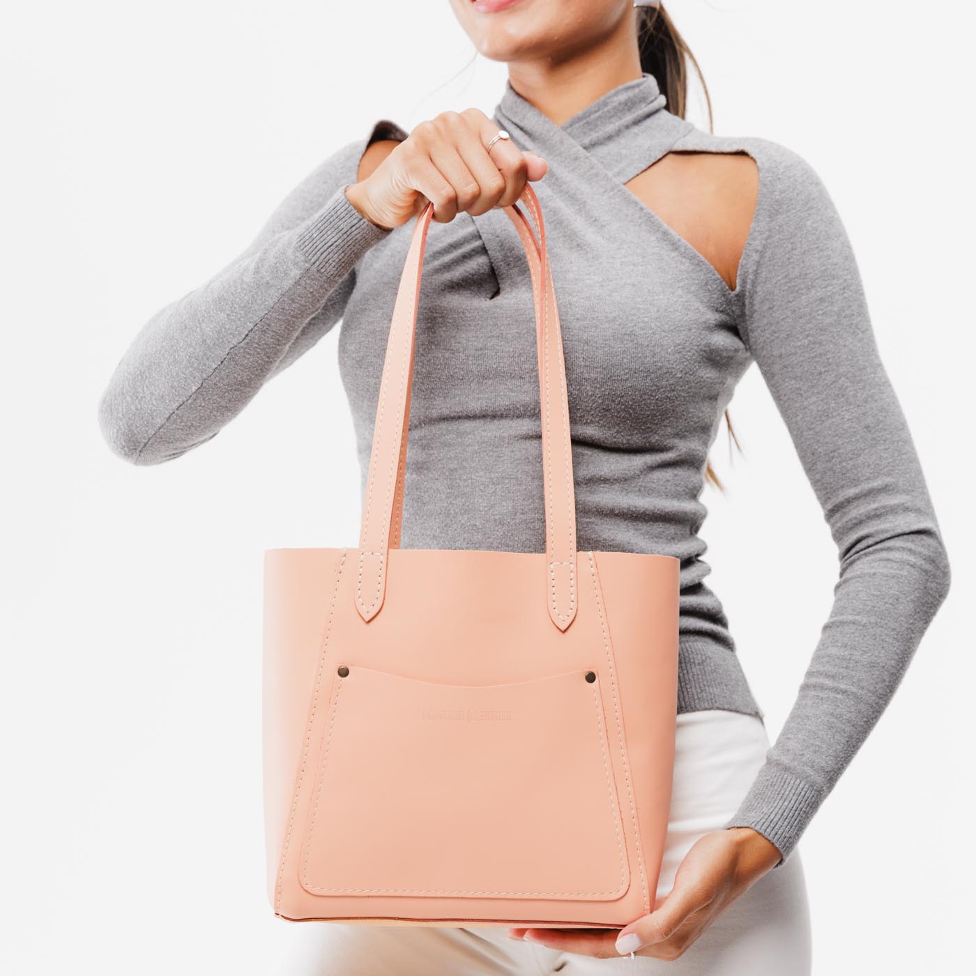 Mamey Small | Model holding dual shoulder strap tote bag with an exterior pocket