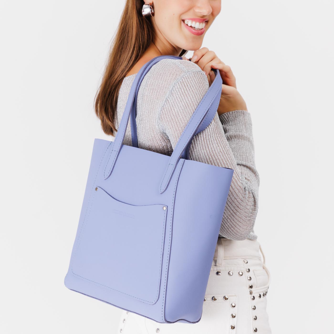 Jacaranda*Large | Model holding dual shoulder strap tote bag with an exterior pocket