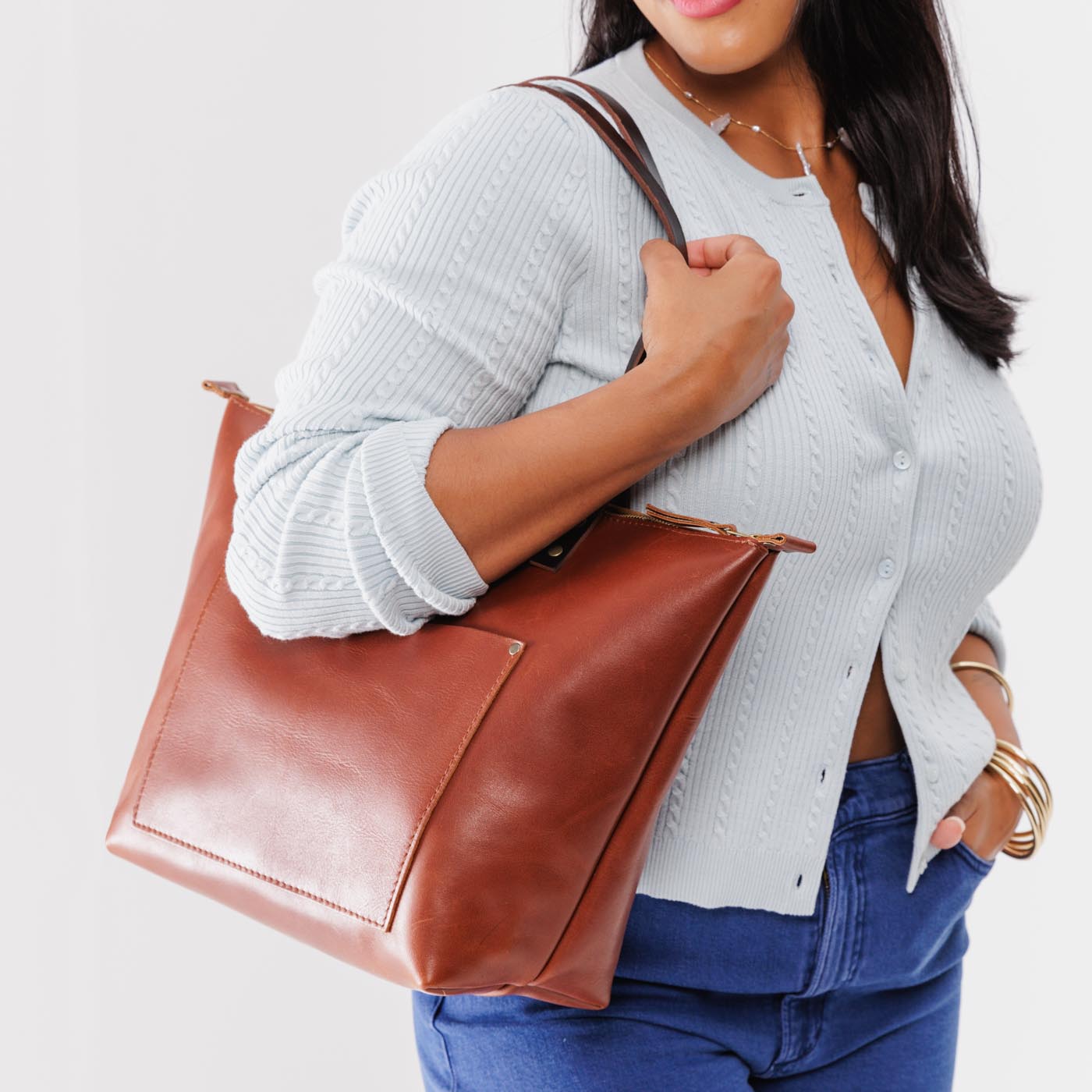 Chestnut*Zipper | Model holding large leather tote bag with sturdy bridle handles and front pocket