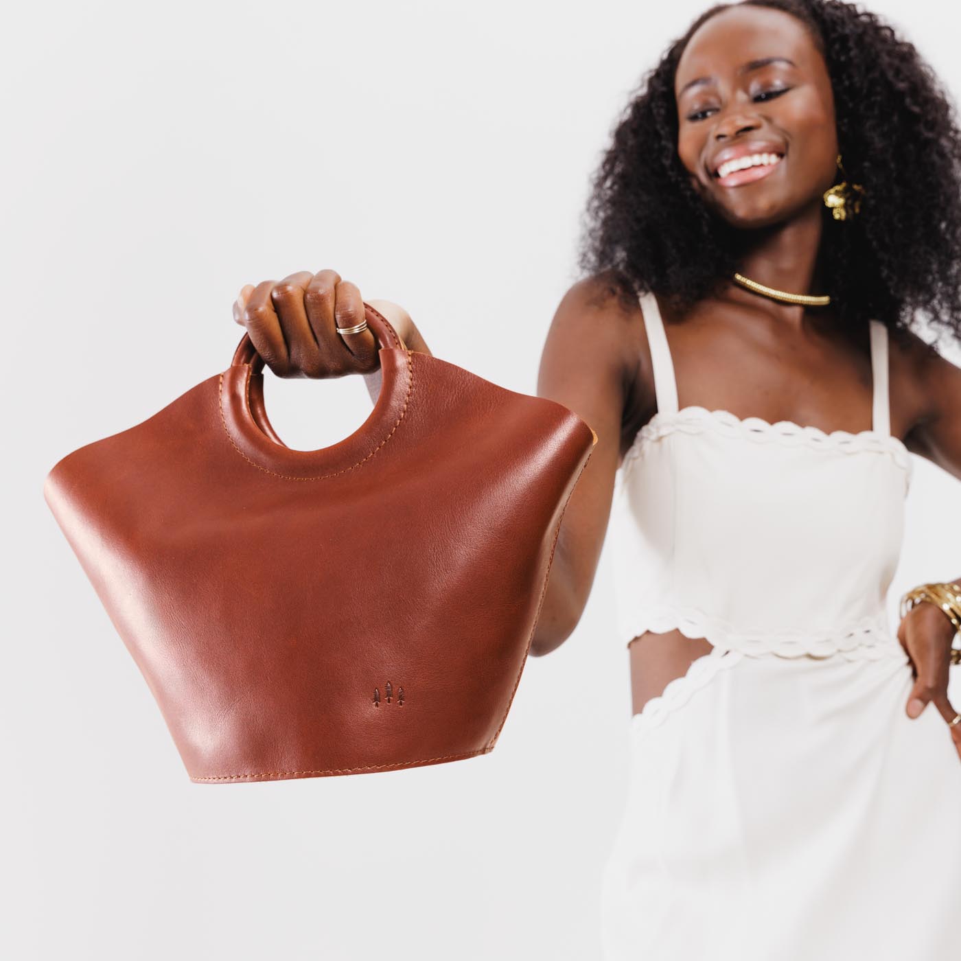 Chestnut*Large | Model holding structured leather hand bag with circular handles