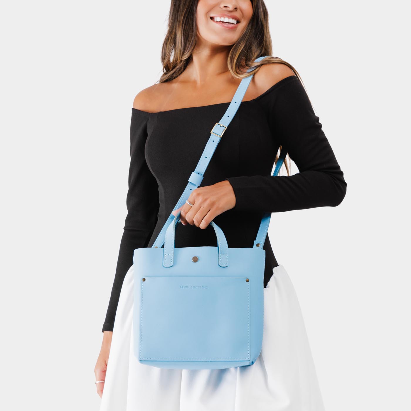 Glacial Blue*Classic | Model holding crossbody tote bag with snap closure and front pocket