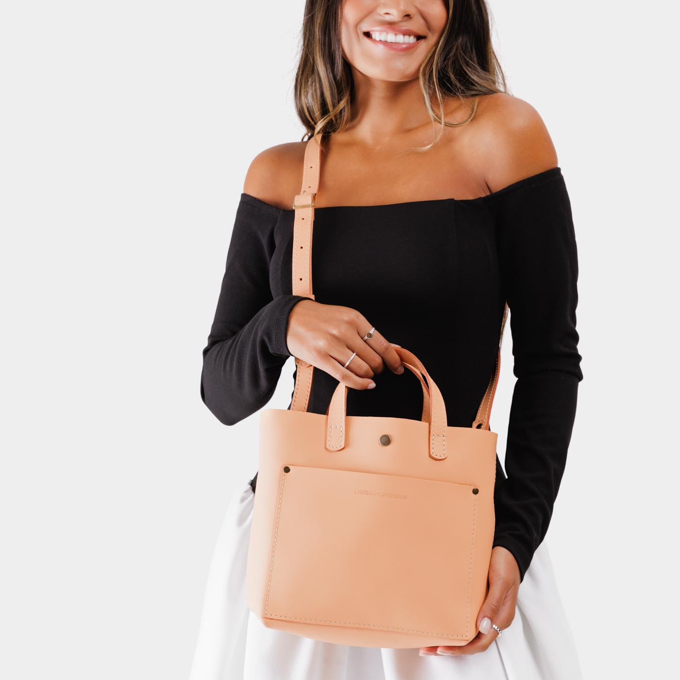 Mamey*Classic | Model holding crossbody tote bag with snap closure and front pocket