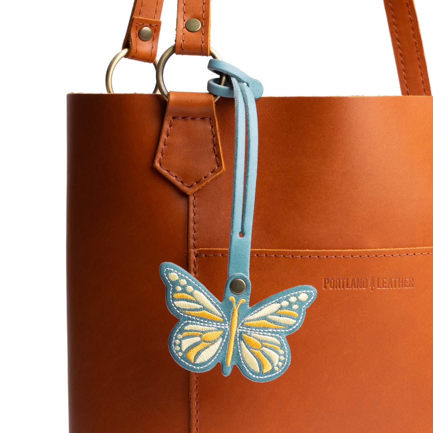 Aqua | Embroidered butterfly tassel accessory on a bag