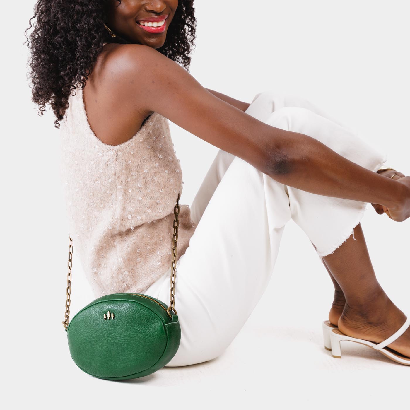 Bacalar | Model wearing oval leather purse with metal crossbody chain strap and adjustable leather shoulder guard