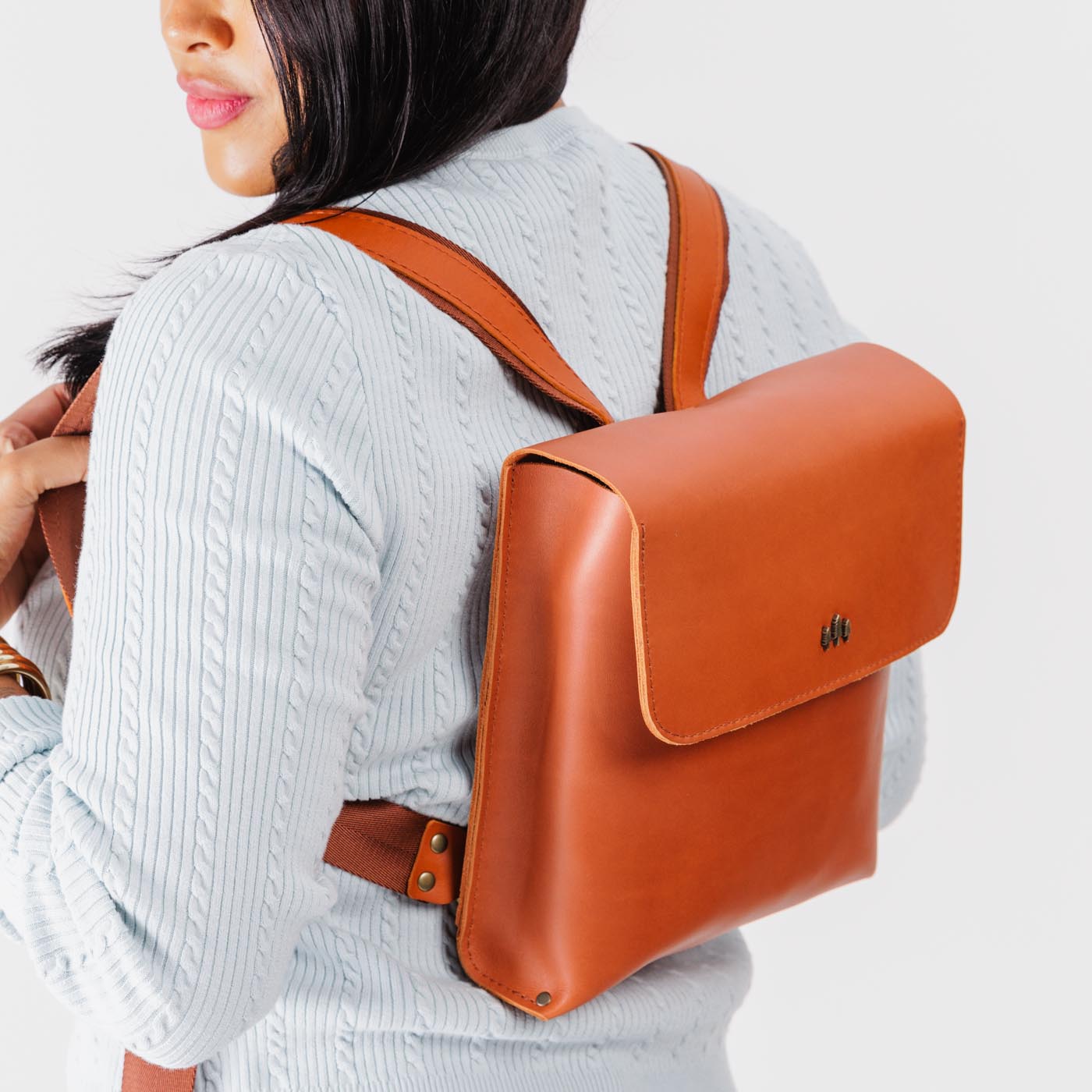 Tuscany | Model wearing rectangular backpack with leather lined nylon straps and magnetic flap closure