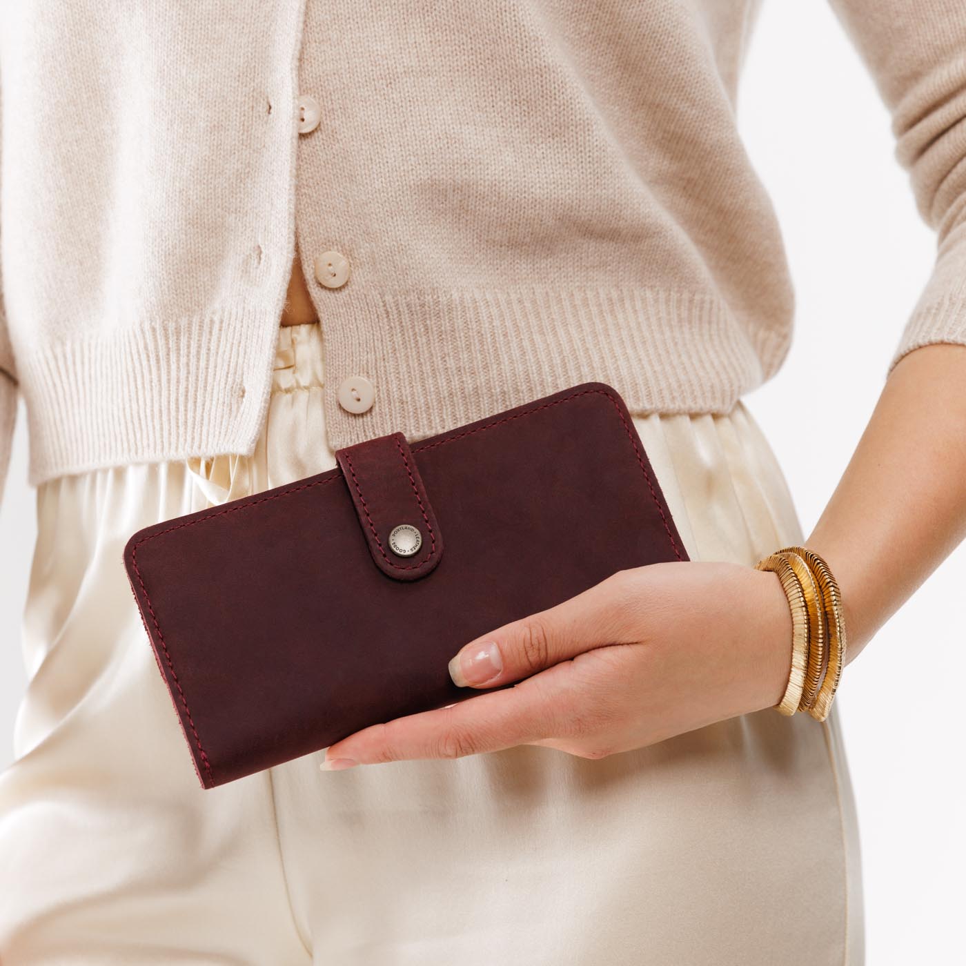 Merlot | Model holding leather wallet with snap open