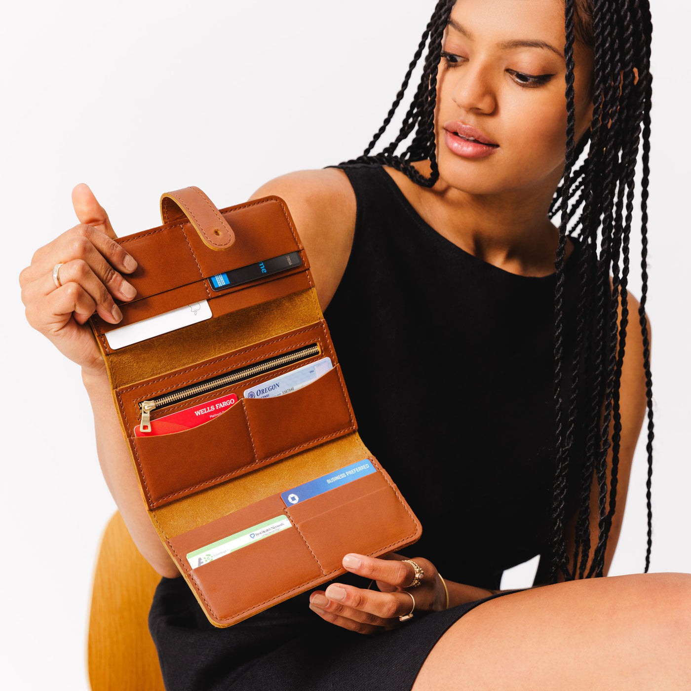 Honey | Model holding leather wallet with Sam Browne closure open