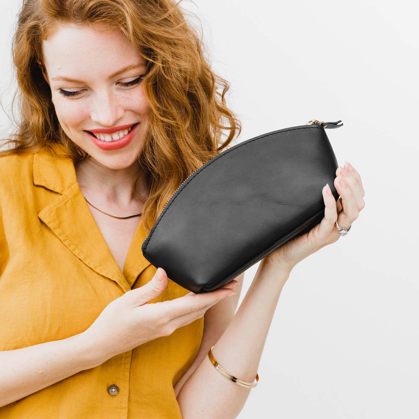 All Color: Black | Spacious leather makeup bag with curved seams and top zipper