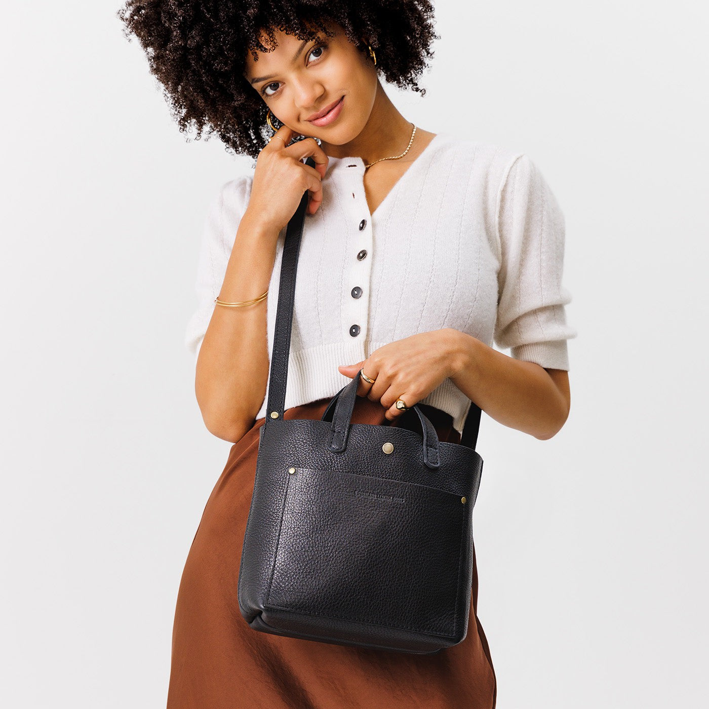 Pebbled--black*Classic | Model holding crossbody tote bag with snap closure and front pocket