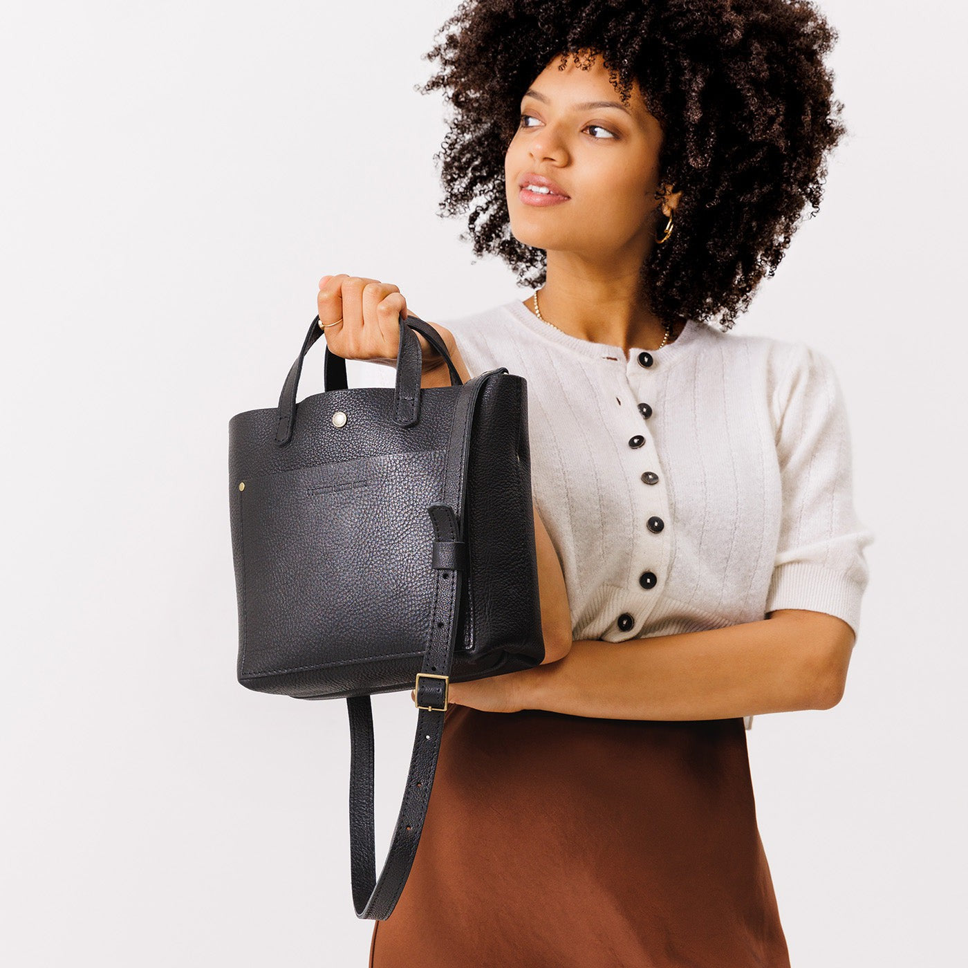 Pebbled--black*Classic | Model holding crossbody tote bag with snap closure and front pocket