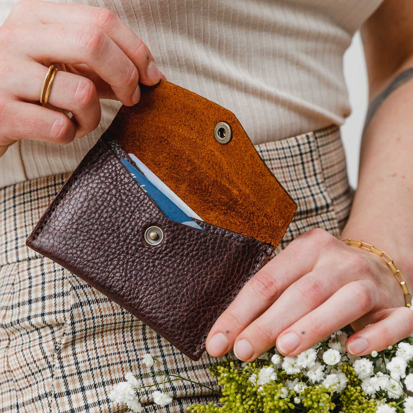 Coldbrew | Model holding small leather envelope wallet with snap closure open