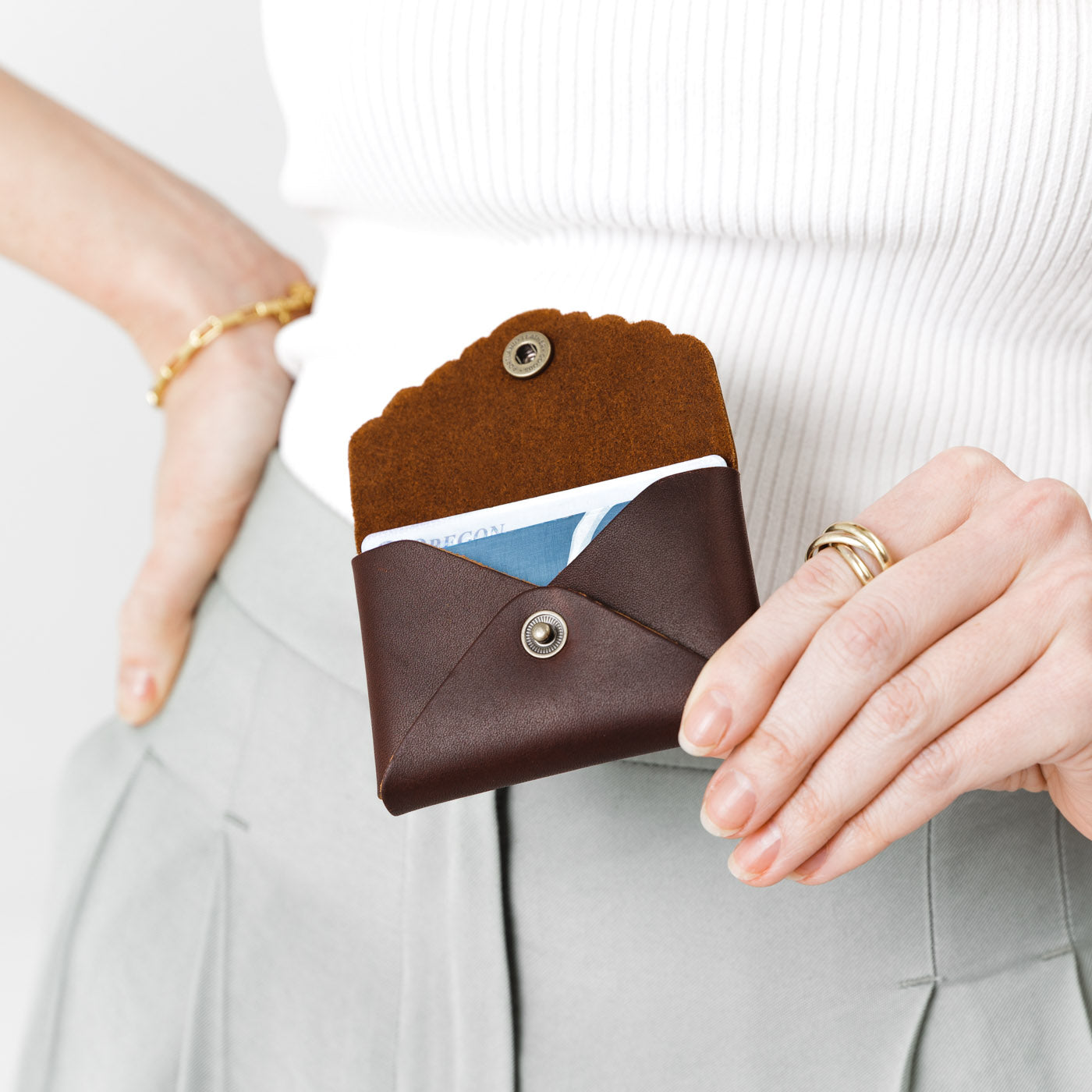 Grizzly | Model holding small leather wallet with scalloped edge open