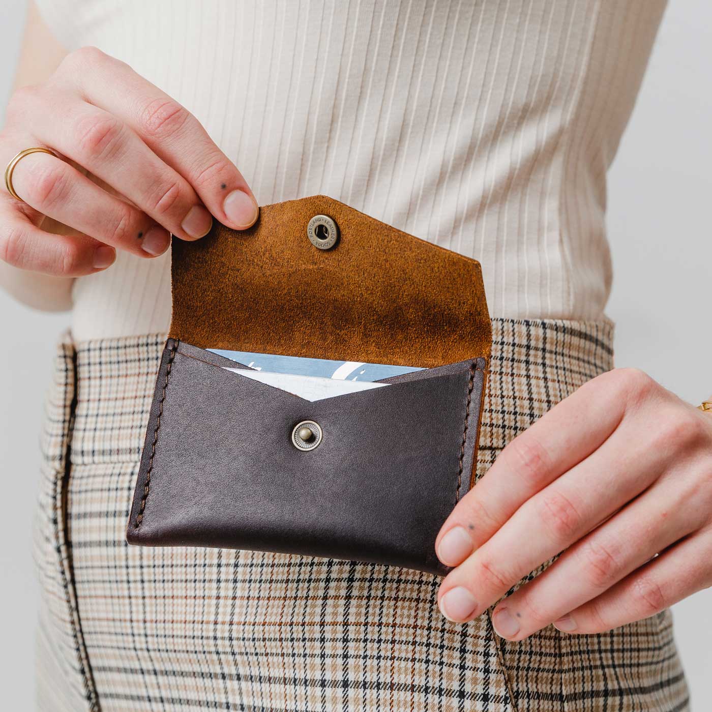 Grizzly | Model holding small leather envelope wallet with snap closure open