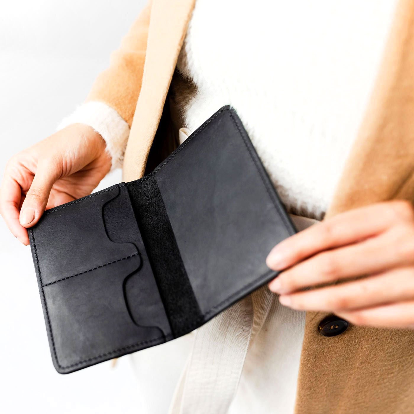 Black | Model holding leather passport case with PLG logo