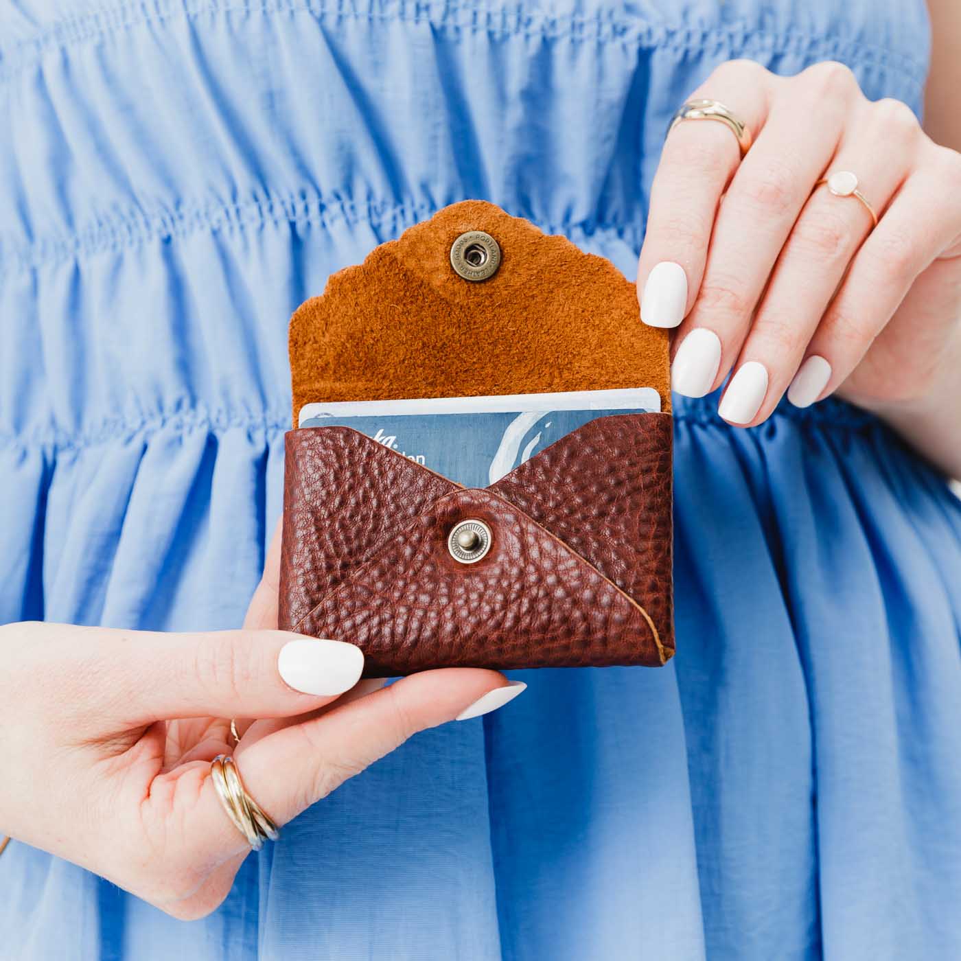 Nutmeg | Model holding small leather wallet with scalloped edge open