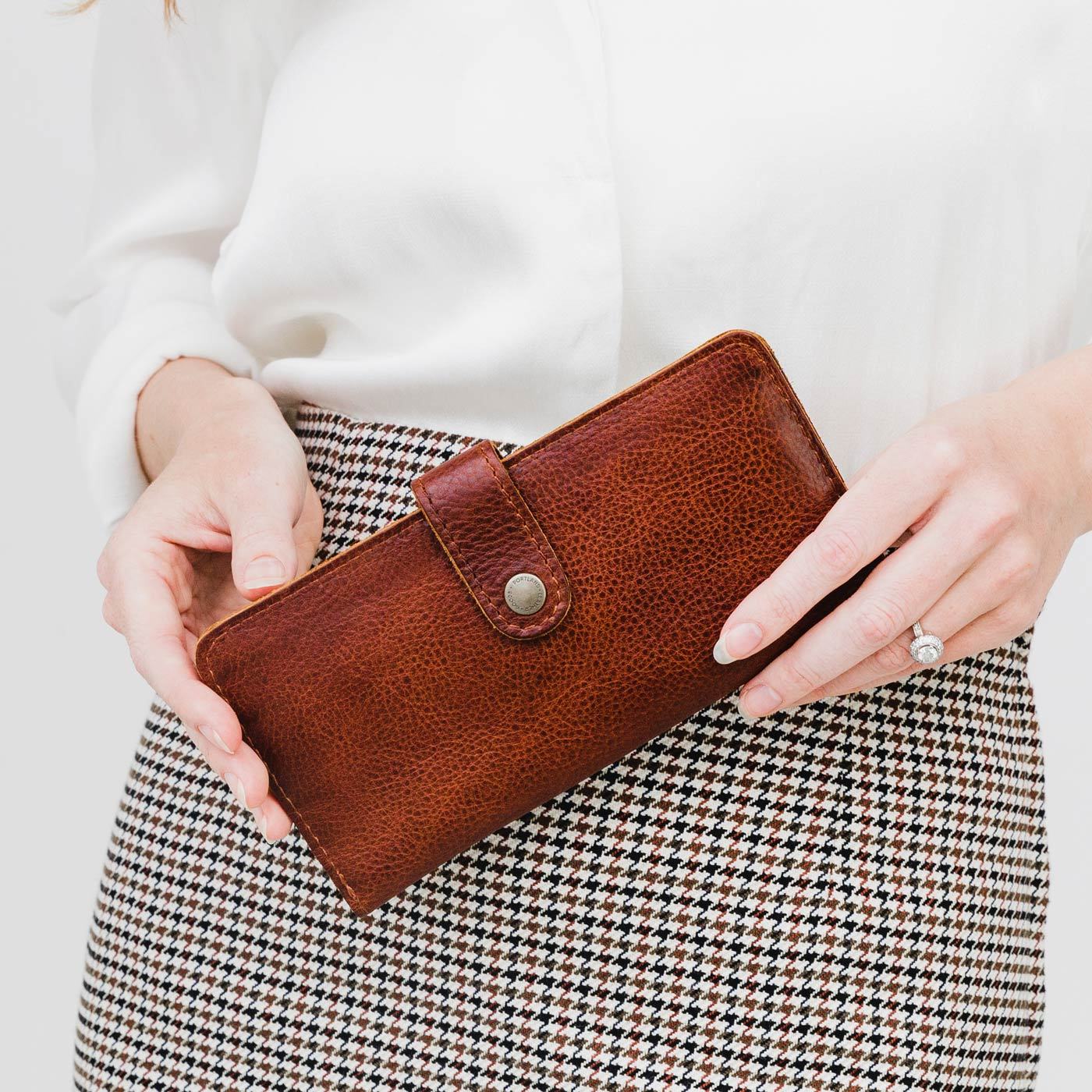 Nutmeg | Model holding leather wallet with snap closed