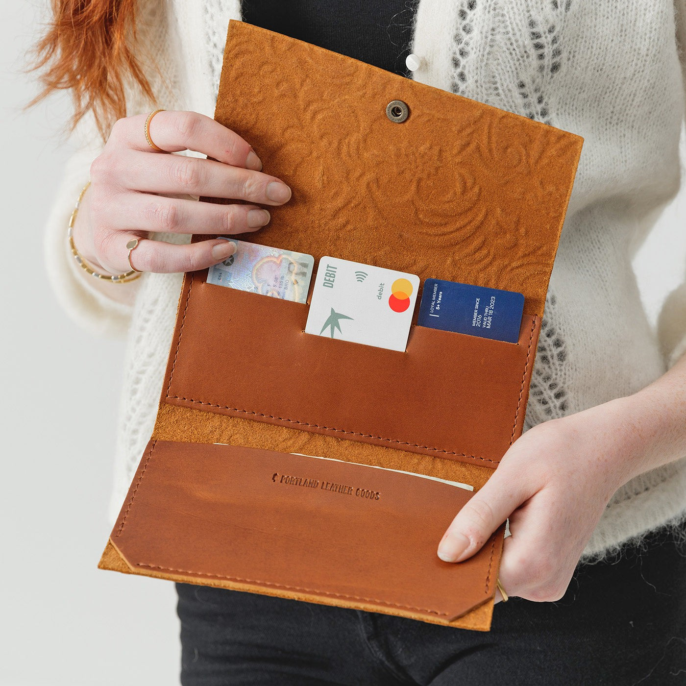 Meadow | Model holding leather wallet with snap closure open